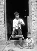 Marcelo a los 4 años. Discapacitado por la polio, vivió en un pueblo a 2 días por sendero desde la carretera más cercana. Aquí se sienta junto a su hermano, que resultó herido cuando un árbol cayó sobre su pierna.