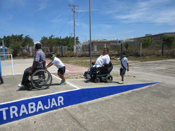 Aquí dos de los integrantes de de silla de Habilítate en silla de ruedas guiando a los niños "ciegos".