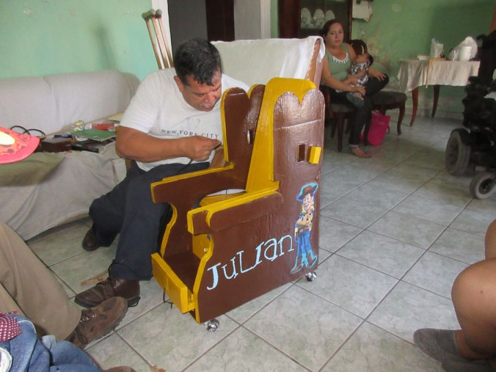 Sergio agrega los toques finales al asiento de Julian, un niño con parálisis cerebral.