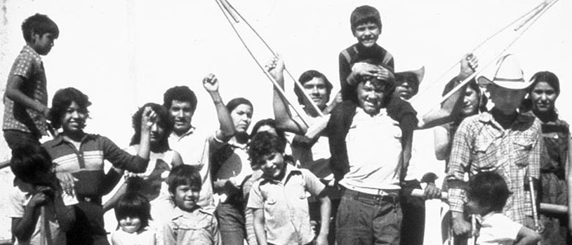 A man surrounded by friends raising his crutches in victory.