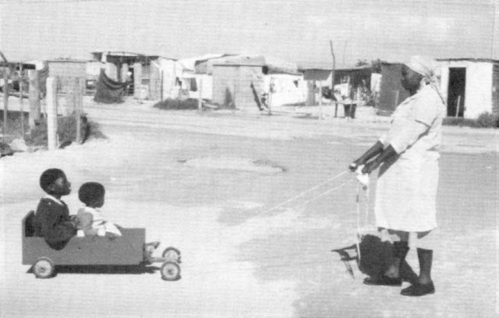 A mother brings her disabled son and baby every day for rehabilitation in a simple cart made in a squatter settlement rehabilitation center in South Africa