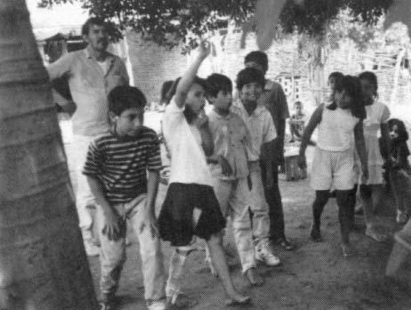 Martín Reyes helps some Ajoya children learn what it is like to have a disability. The children are preparing to race, some ‘handicapped’ by having a stick tied to their legs.