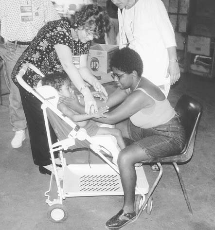 Course participants teach Maria, who is mentally handicapped, to help care for a profoundly disabled child. Here Maria learns simple activities to help the child gain better head control.