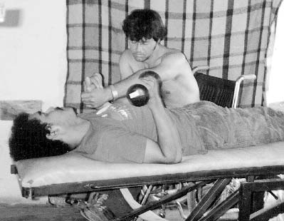 Inez helps Che—the left half of whose body was paralyzed by a bullet wound in the head—maintain range-of-motion in his weak left arm and increase the strength of his right arm. (See story, page 253.)