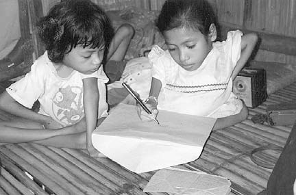 Jenny demonstrates how well she can write, while Mercy watches. The 3sisters are eager to become pen pals with Virginia in Mexico, who also hasthe brittle-bone condition.