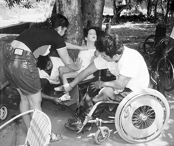 Gabriel Zepeda, a skilled wheelchair builder, measures a girl with spastic cerebral palsy for an individualized wheelchair. The girl sits in a specially designed measuring seat.