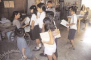 Marielos gives children pointers on the wooden puzzles they are making.