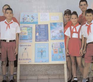 School children and CBR Activists pose next to disability awareness-raising posters.