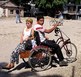 With this hand-powered "bici-taxi" a disabled man gives a ride to a disabled woman. (She said she was not afraid of falling.)