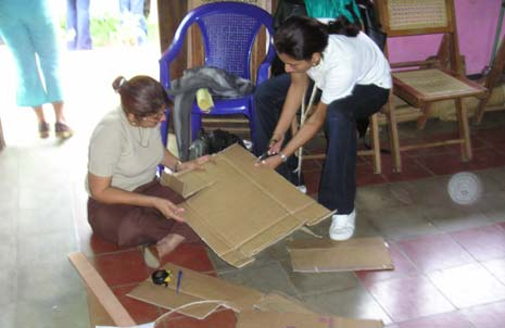 Participants cut up old cardboard boxes, which they will glue together to make a cardboard seat.