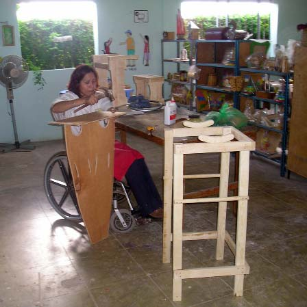 Here Marielos, who runs the PROJIMO crafts shop, works on a parapodium to help a disabled child start walking.