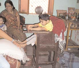 His mother props the feet up against the bed, but this triggers spastic extension of his body.