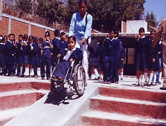 Local masons built a ramp so Magali can go up the steps. The ramp is quite steep, but there are plenty of people to help her.