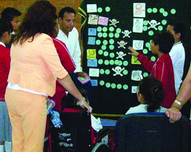 In the other "community diagnosis" group using the flannel-graph, the children also made sure the children in wheelchairs helped to pick the health problems they considered important, and place the pictures of them on the display. It was clear they took pride in making sure every child took part.