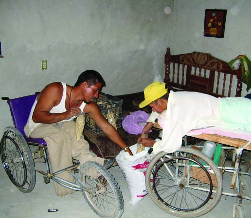 Jesus has gone into partnership with Atilano, who is spinal cord injured and rides a gurney while he recovers from pressure sores. Here they are packaging the peanuts.