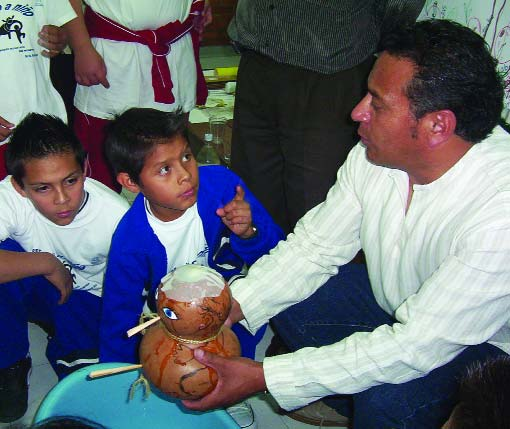 These boys are learning how to teach using the gourd baby. The gourd baby illustrates how liquid is lost when a child has diarrhea, and how much needs to be put back in to prevent severe dehydration.