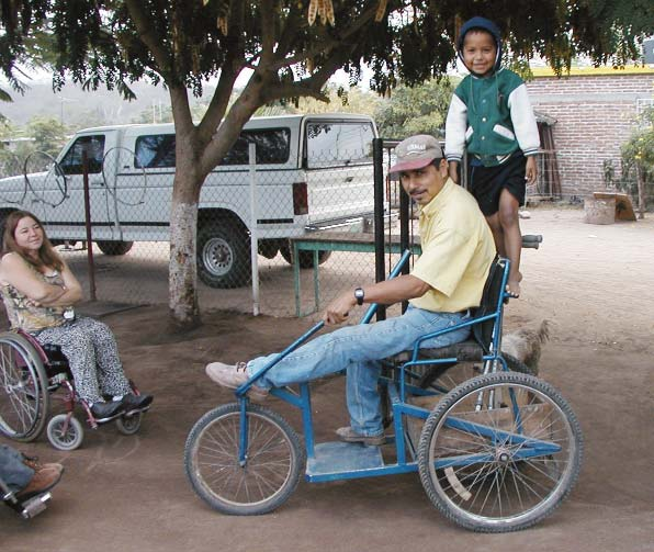 José Luis hitches a ride with Marcelo on his hand-powered tricycle.