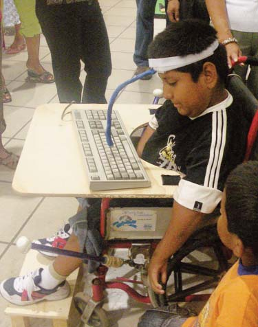 Daniel shows how he can play computer games with a head band and pointer made by his group. He learned to use it very quickly.