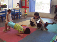 The children help one another with therapy and exercise. Here Benigno helps Luis prepare for walking, while two of the girls practice their exercises.