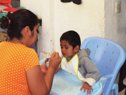 When he arrived at the Home Shelter at age 3, Luis could not speak, walk or feed himself. Here Coco’s daughter feeds him.