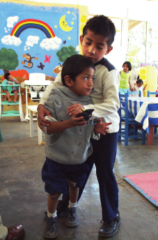 With the willing help of Benigno and the other children, Luis is learning to walk.