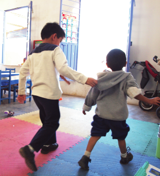 Benigno has learned how to provide the minimum amount of assistance to help his young friend do the maximum amount for himself. Here he holds Luis’ hood to give the timid boy assurance that if he begins to fall he won’t be hurt.