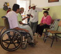 Rigo and David Werner discuss possibilities with Minerva, who has club feet. A wheelchair will be designed and built for her in the Duranguito wheelchair shop.