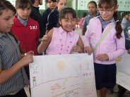 Children in one of Rigo’s programs show their posters on accident prevention.