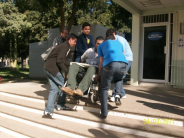 Helpful students of UAS help Rigo up the stairs.