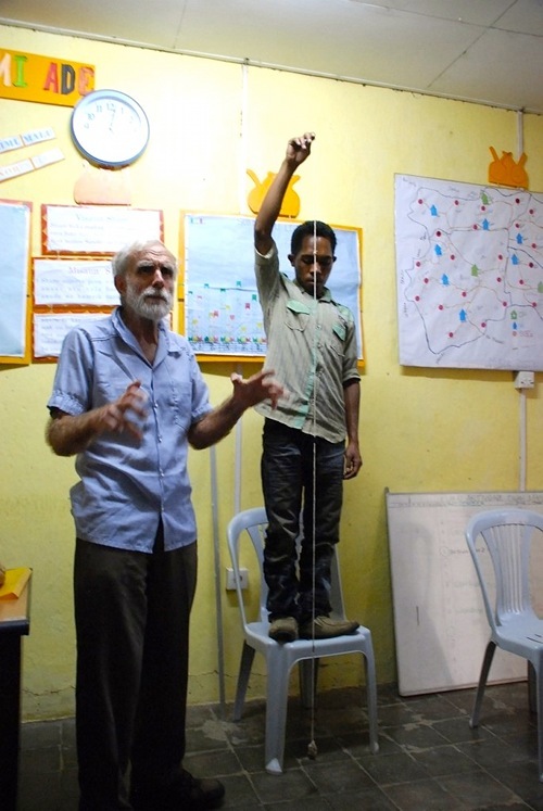 Here the SHARE team learn to time the rate of breathing using a rock swinging on a string. A healthy adult breathes at about 31 breaths a minute (speed of the rock swinging on 2 meters of string.) A baby who breaths faster than a rock swings on 35 cm. of string (50 swings a minute) probably has pneumonia.