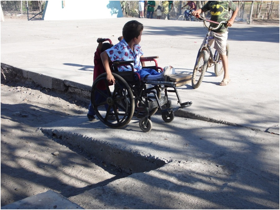Here Miguel Angel's little brother helps push his wheelchair up one of the new ramps.