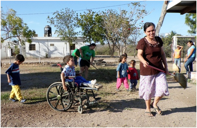 But assistance is mutual. Here Miguel Angel's grandma helps clean up the schoolyard on a community work day.