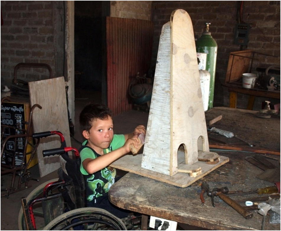 Eager to start standing, Miguel Angel helps sand his standing frame...