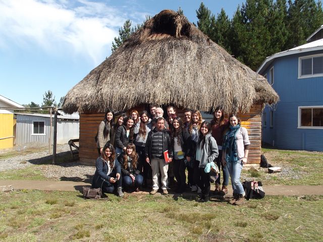 Student occupational therapist pose with the chief shaman (white pants) in front to the ‘ruca,’ (traditional Mapuche house), which at the ‘Centro’ is used as a meeting hall and classroom.