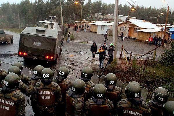 Chilean ‘carbineros’ (rifle-bearing police) try to intimidate a Mapuche settlement.