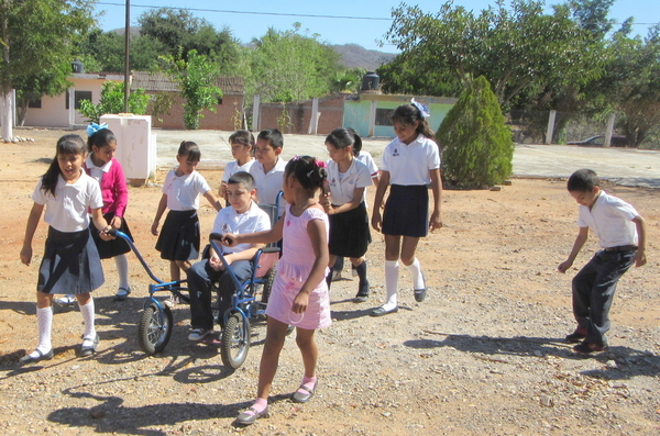 Tonio sat in his carriage and let his classmates wheel him around the playground.