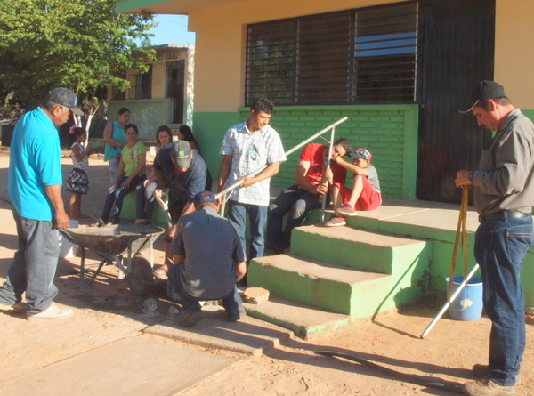 The school supplied leftover cement, sand and gravel from an earlier project. Someone brought a wheelbarrow to mix the concrete in; the uprights were vertically leveled.