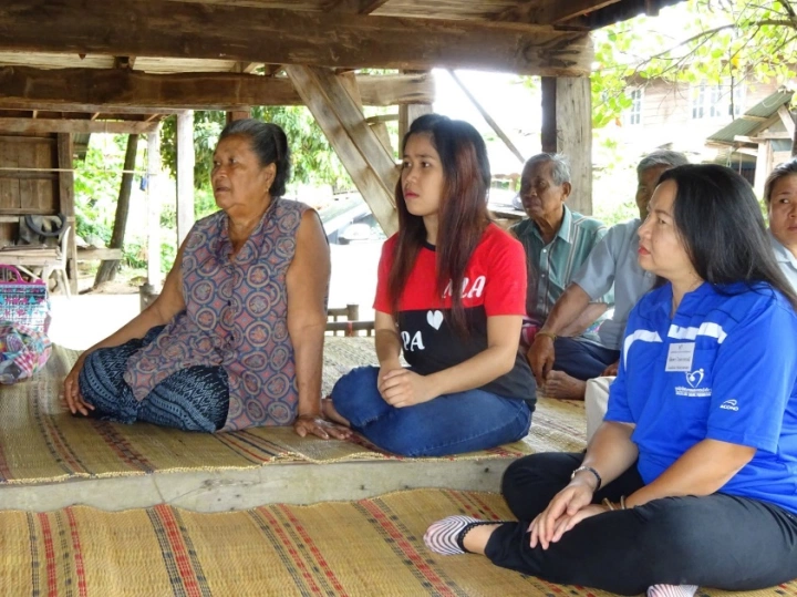 Mai (in red shirt) and her grandmother, who raised her since infancy after her parents died.