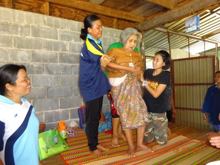 Here the health volunteer and the bed-ridden woman’s "buddy" help her to stand, which she had insisted she couldn’t do. Once she found she could stand, and even take a few steps, she was happier and wanted to become more active.