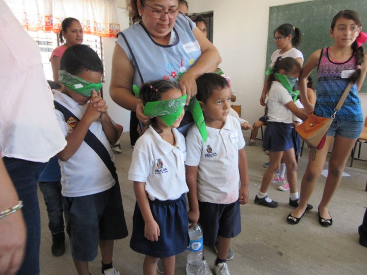 Simulation games helped participants get a taste of different disabilities. Here mothers help blindfold some of the children.