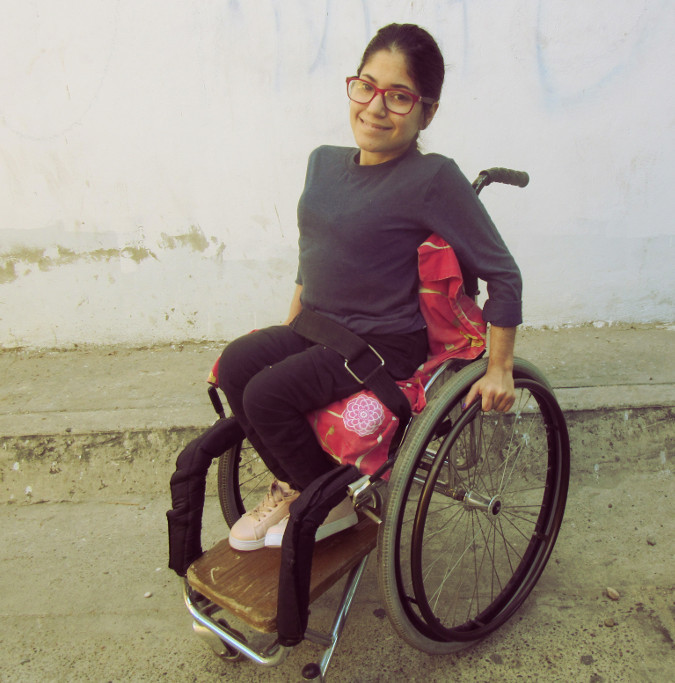 Mónica sits on her modified wheelchair.